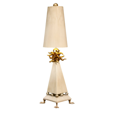 Introducing the Leda 1 Light Table Lamp, featuring a tall, tapered shade and adorned with a gold leaf cherub accent at its center. Its base showcases a cream patina finish in a pyramid shape with spherical feet, perfectly blending classic elegance with whimsical charm.
