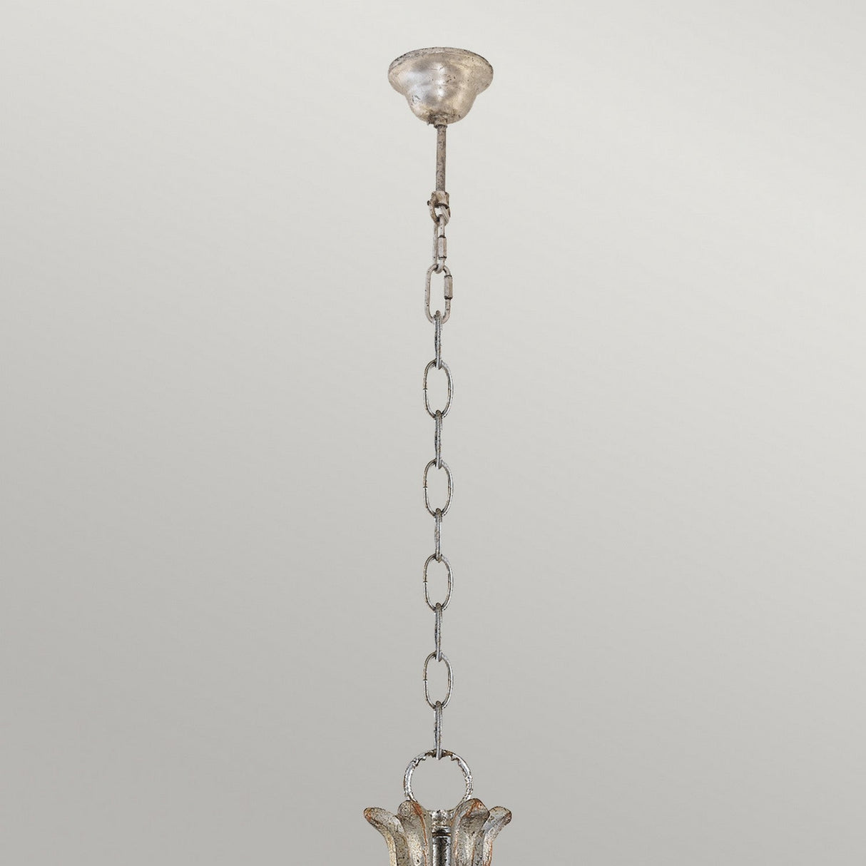 Introducing the Remi 5 Light Chandelier in Silver & Gold: an elegant design featuring a decorative hanging light fixture. This chandelier boasts a vintage-style metallic finish, highlighted by a stunning open petal-like design, and is suspended by a chain extending from the ceiling. Perfectly crafted against a plain light background, this piece embodies traditional craftsmanship.