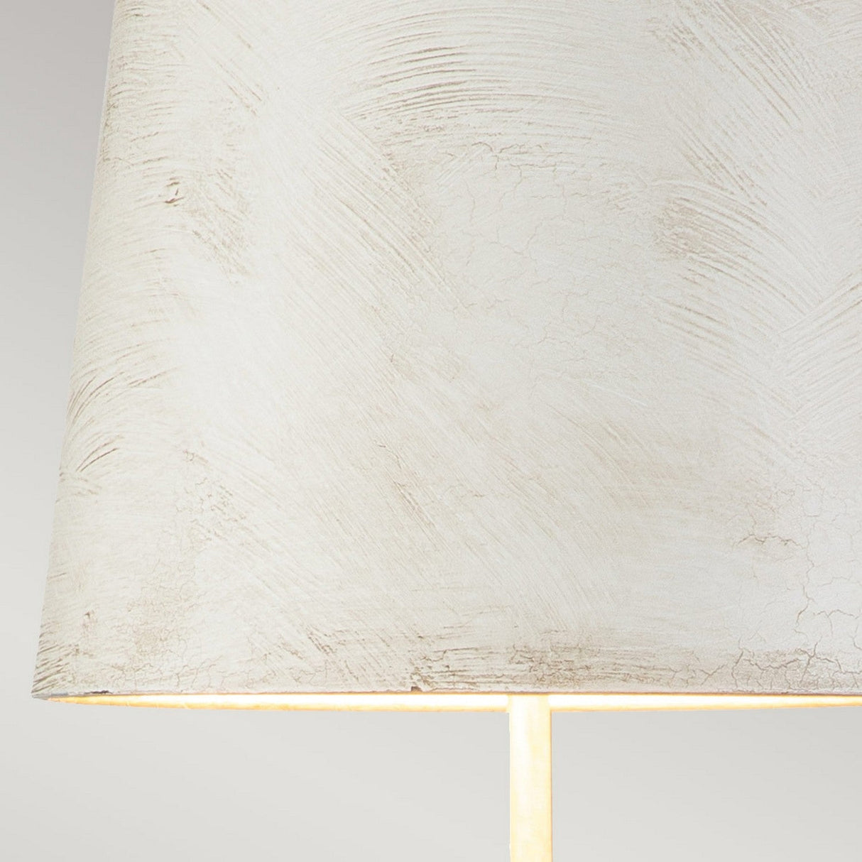 Close-up of the Swirl 1 Light Table Lamp in white and black, featuring a textured, antique white conical shade. Its subtle swirling pattern enhances the contemporary design and emits a soft, warm glow from below, against a gradient light gray background.