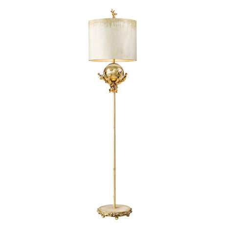 A tall, elegant floor lamp with a Putty Patina decorated base and ornate detailing in Silver Leaf. This decorative lighting piece showcases a spherical accent and a cylindrical, cream-colored lampshade with textured design near the top, enhanced by subtle hand-painted flourishes.