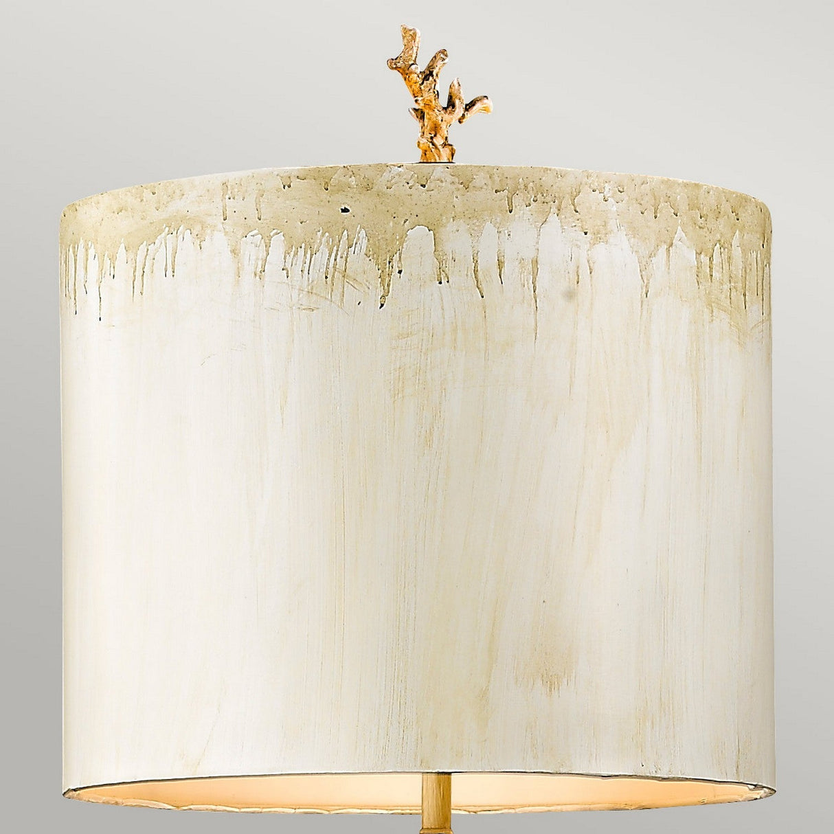 The Trellis 1 Light Floor Lamp in Putty Patina and Silver Leaf features a beige lampshade with a drip effect on top, complemented by a gold branch-like finial on a neutral background, adding an elegant touch to any room.