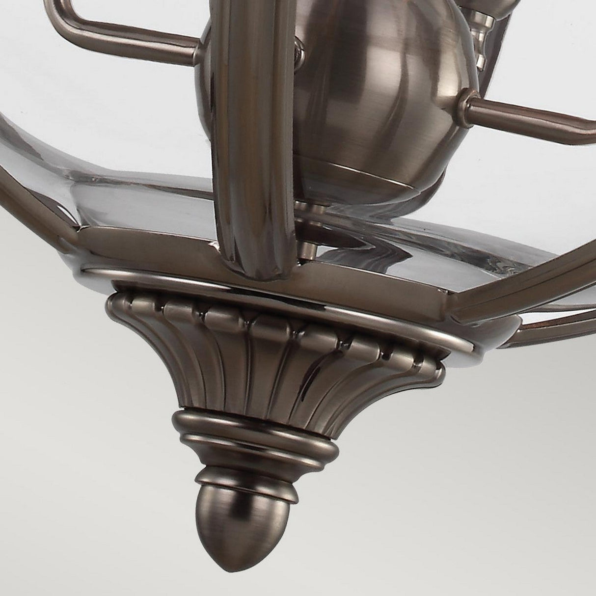 Close-up of the Adams 4 Light Chandelier - Antique Nickel showcasing a metallic fixture with a glass enclosure and decorative detailing. The Antique Nickel finish exudes Victorian-inspired elegance, offering a combination of modern yet timeless style.