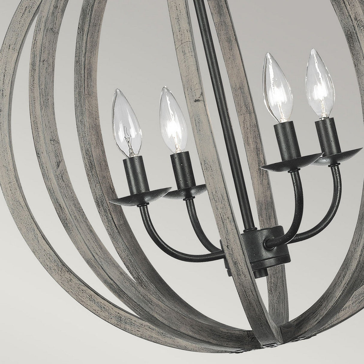 The Allier 4 Light Chandelier features a rustic wooden frame in weathered oak that encases four candle-like bulbs, all elegantly mounted on an antique forged iron fixture for a striking contrast against the soft wood texture.