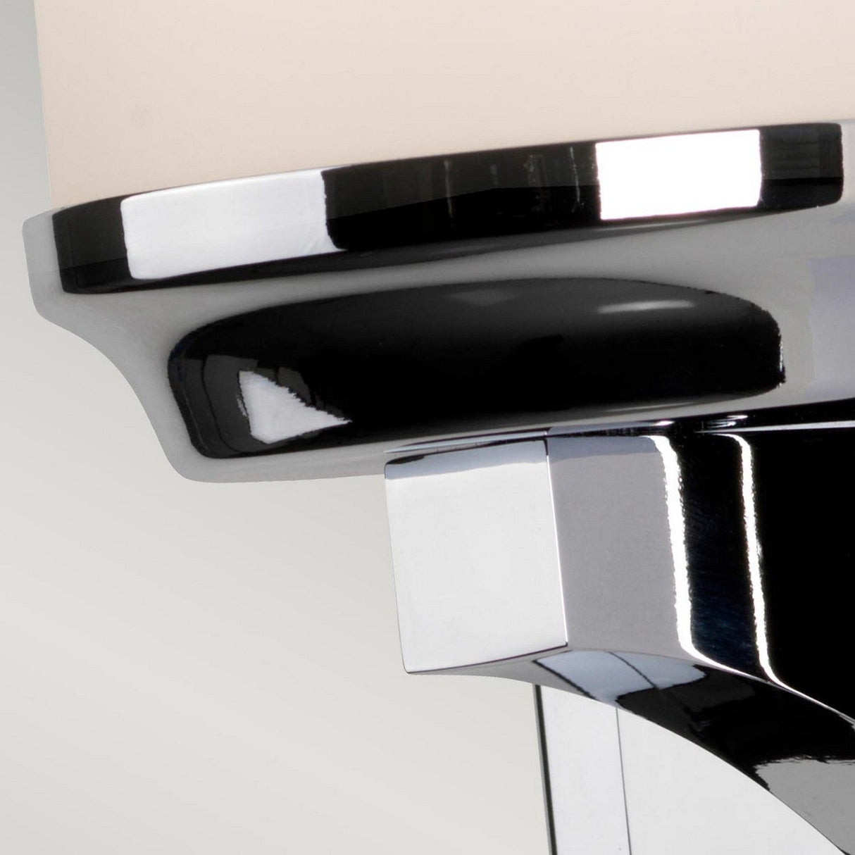 Close-up of a modern chrome bathroom faucet featuring a shiny finish and polished chrome accents. The focus is on the sleek design and reflective surface against a neutral background, complementing fixtures such as the Amalia 1 Light Large Wall Light in Polished Chrome.