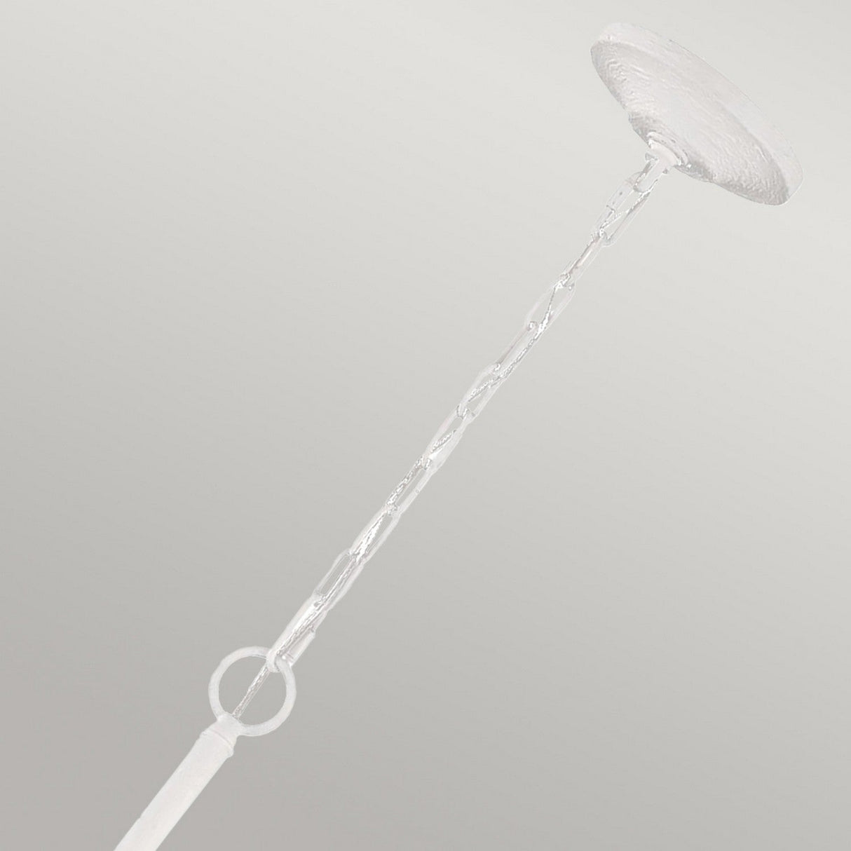 A textured plaster white Annie 4 Light Chandelier hangs elegantly against a plain background, showcasing its coastal-inspired charm with its twisted glass rod design and unique flat disk accents.