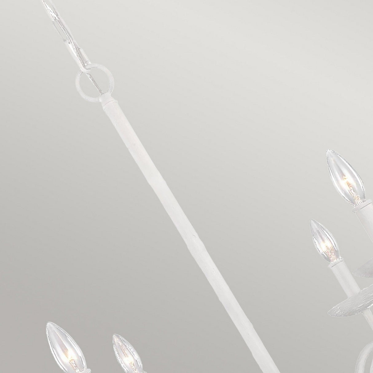Close-up of the Annie 4 Light Chandelier - Textured Plaster White, showcasing its candle-shaped bulbs. This fixture exudes coastal-inspired elegance with a sleek, minimalistic design set against a textured plaster finish.