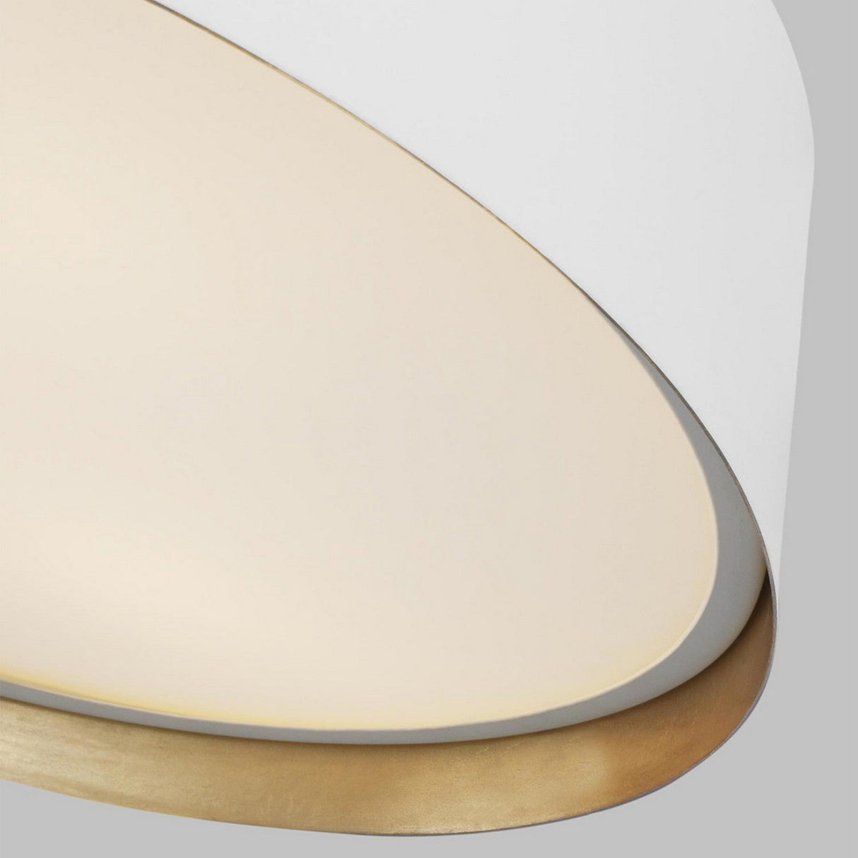 Close-up of the Asher 3 Light Flush fixture, featuring a modern matte white and egg-shaped shade with a warm golden interior that emits a gentle, diffused glow. Its elegant design enhances minimalist interiors and is displayed against a simple gray backdrop.