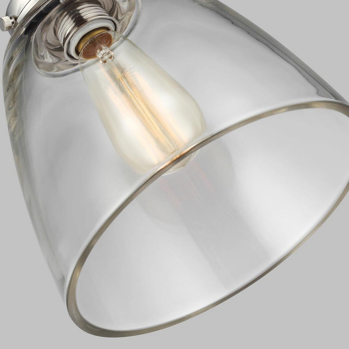 Close-up of the Baskin-2 1 Light Pendant in polished nickel, featuring a clear glass shade and a vintage-style Edison bulb within, set against a gray background. The modern aesthetics are enhanced by the visible filament elegantly displayed through the transparent glass.