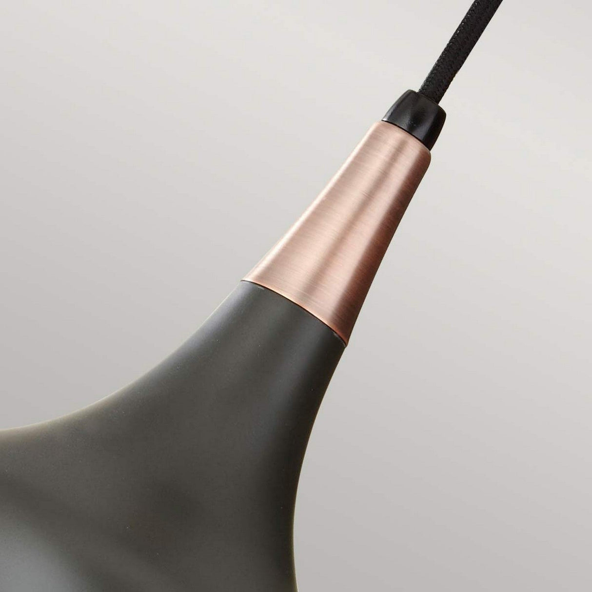 Close-up of the Beso 1 Light Mini Pendant, featuring a contemporary design in a sleek matte black finish with a dark bronze accent near the top. This task lighting fixture is suspended from a black cord against a plain gray background.