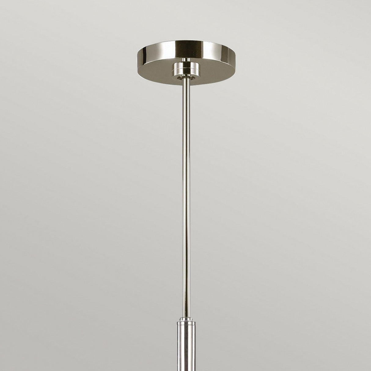 The Brianna 6 Light Chandelier in polished nickel showcases a sleek, minimalist design with a metallic circular base and a single straight rod, elegantly set against a plain gray background, epitomizing modern lighting.