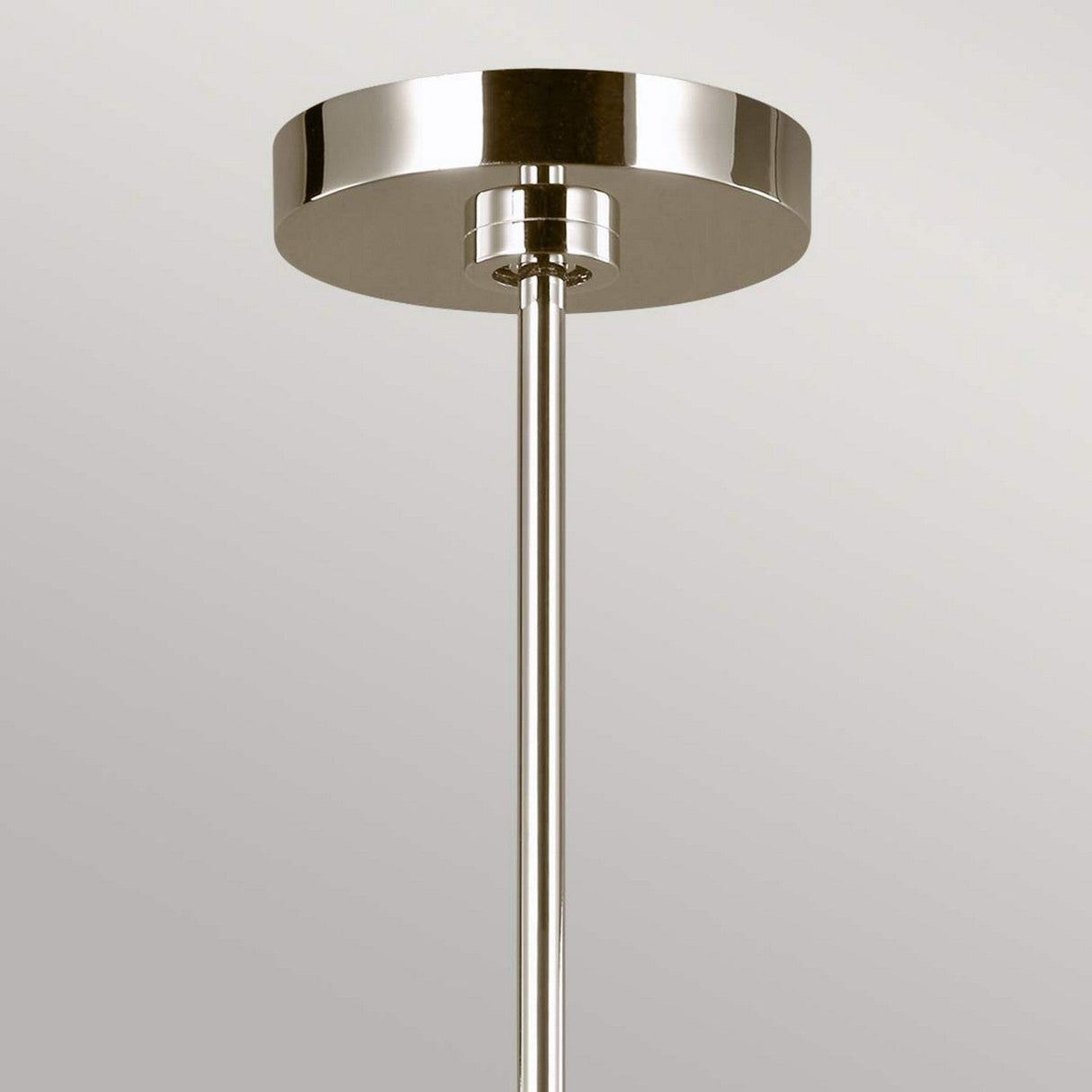 A close-up of the Brianna 9 Light Chandelier in Polished Nickel highlights its sleek metallic finish. The design includes a simple round base and rod, exuding a minimalist and contemporary style set against a neutral background. This modern luxury lighting piece enhances any space with its elegant charm.