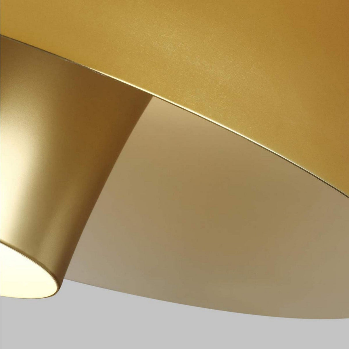 A detailed view of the Brisbin 1 Light Pendant in burnished brass showcases its sleek, conical form. The light gently bounces off its surface, creating a cozy and refined atmosphere against a simple gray backdrop, perfectly capturing the enduring charm of mid-century design.