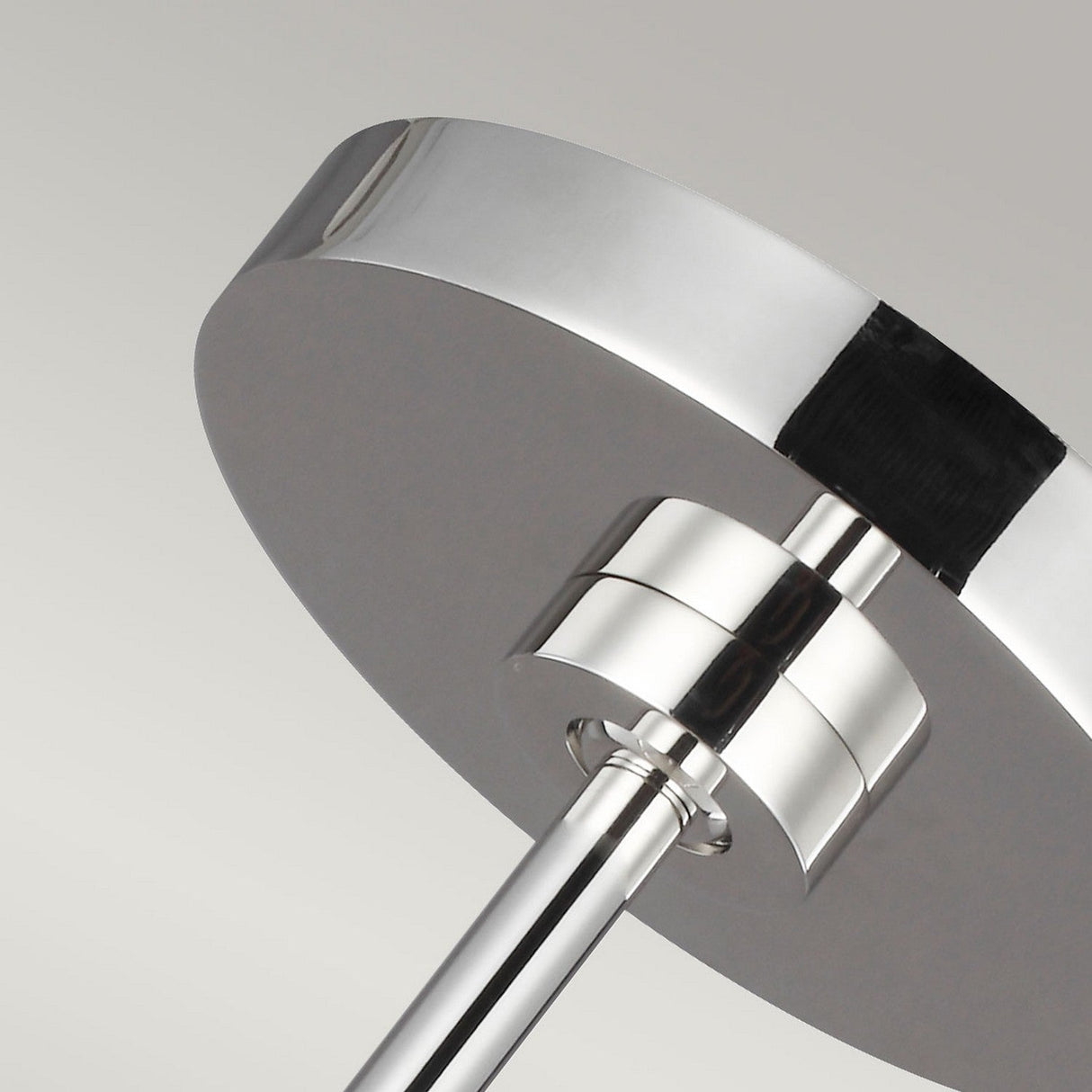 A close-up of the Brisbin 1 Light Pendant features a modern, sleek design with a circular shade. Its polished nickel finish reflects light beautifully, showcasing its mid-century modern style against a simple, neutral backdrop.