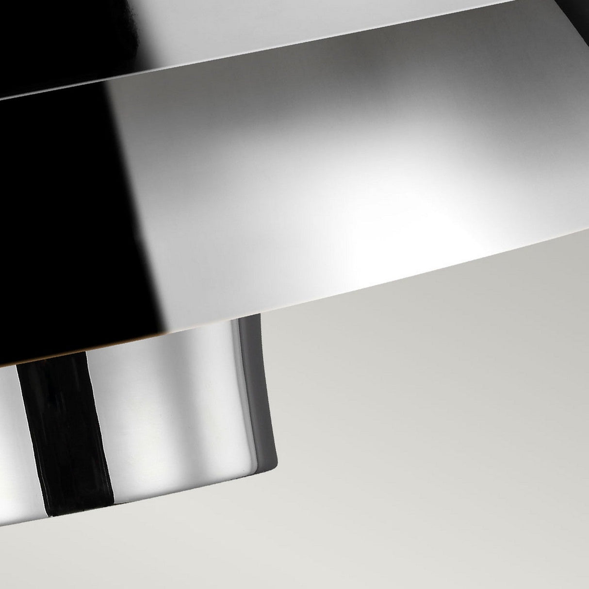 The image highlights the smooth texture and clean lines of the Brisbin 1 Light Pendant - Polished Nickel, emphasizing its minimalist design with reflective properties. This sleek, mid-century modern piece is set against a neutral background.