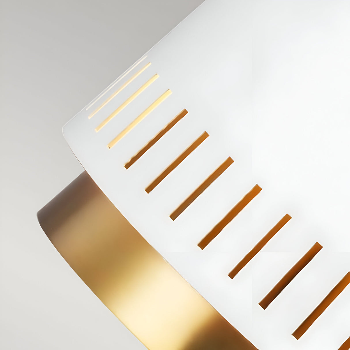 The image provides a close-up of the Carter 1 Light Pendant, featuring a matte white shade with linear cutouts and brass accents that create a warm, indirect light effect. Its sleek and elegant design is perfect for contemporary interiors.
