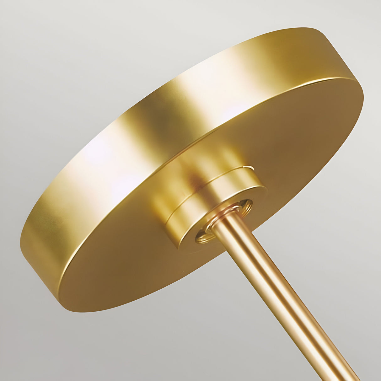 Close-up of the Carter 1 Light Pendant, showcasing its matte white finish complemented by elegant brass accents. Featuring a smooth, circular top connected to a slender pole in brass, it stands out beautifully against a light, neutral background. Ideal for contemporary interiors with its sleek and sophisticated design.