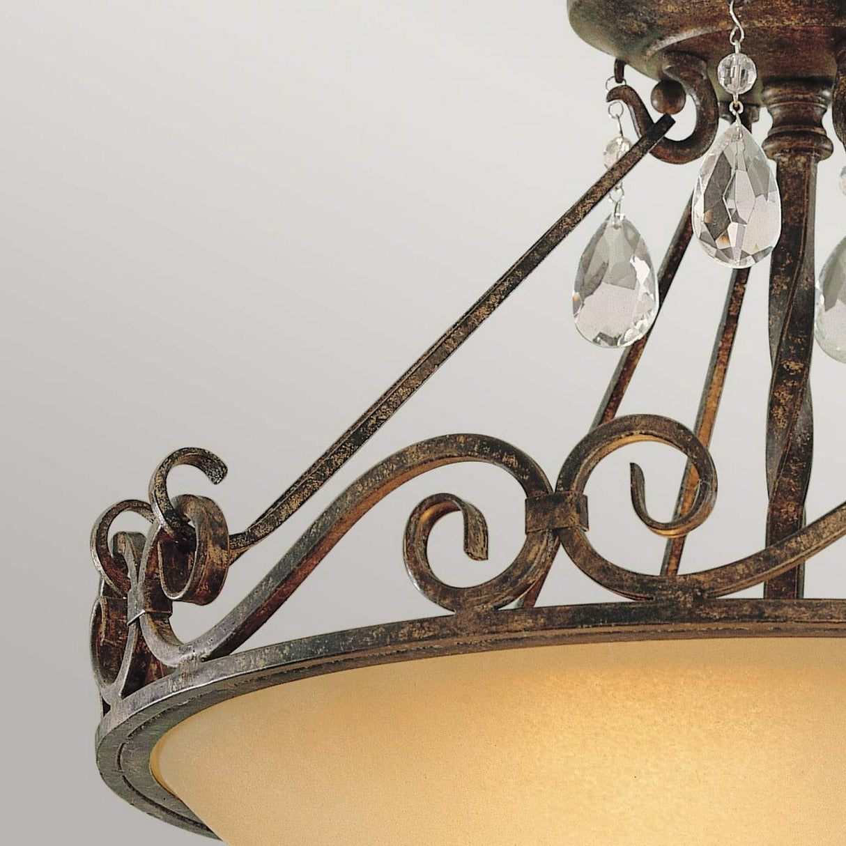 A detailed look at the Chateau 2 Light Semi Flush in mocha bronze reveals intricate scrollwork, complemented by clear crystal accents that hang with elegance. The fixture's shade features a warm beige color, adding to its timeless appeal.