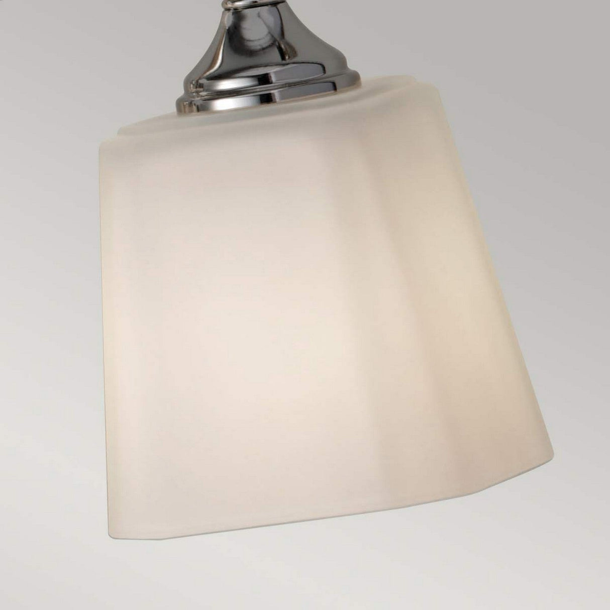 A close-up of a modern pendant light fixture features a polished chrome mount supporting an opal-etched glass shade, with the neutral background highlighting its contemporary design, similar to the Concord 4 Light Wall Light - Polished Chrome.