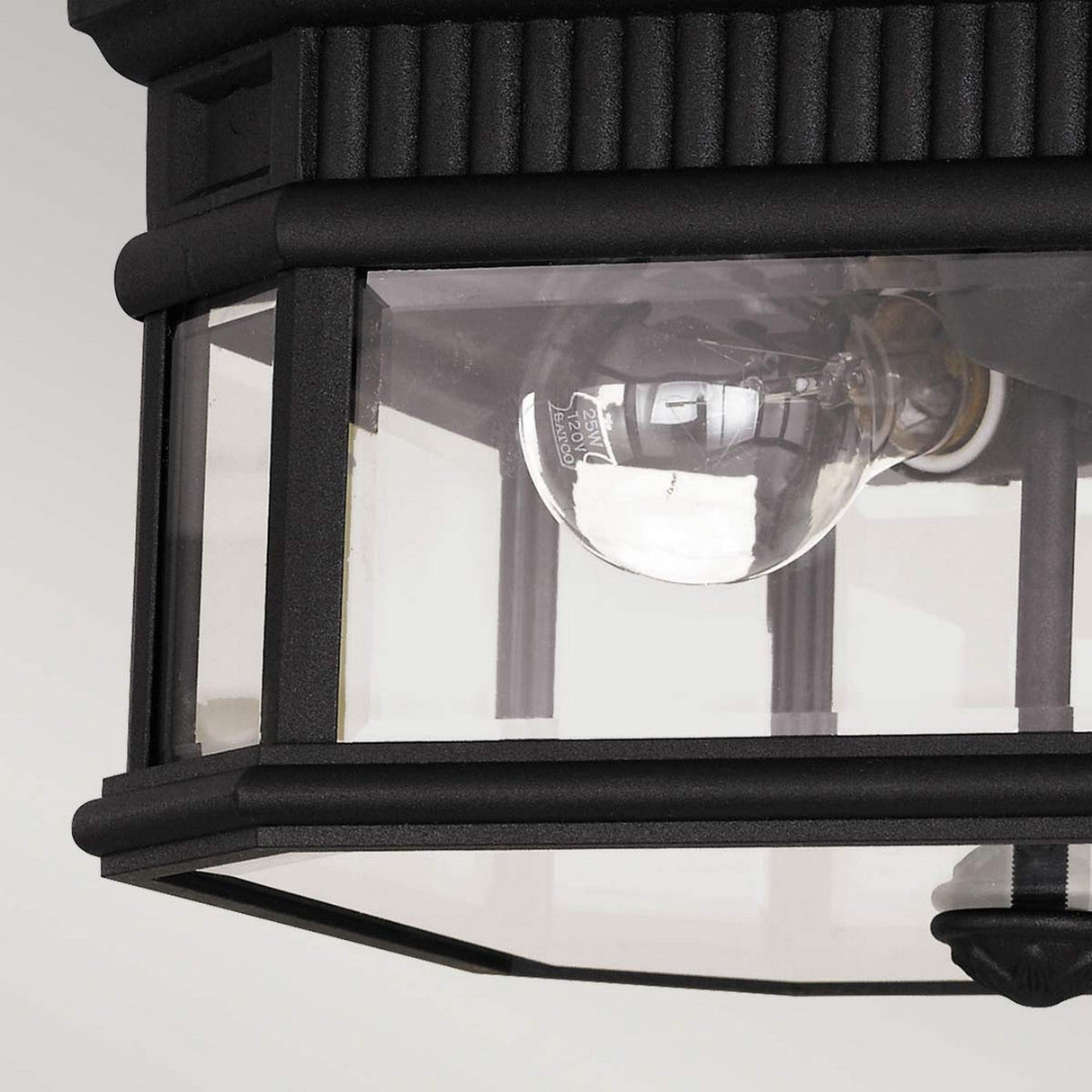 Close-up of the Cotswold Lane 2 Light Outdoor Flush in black, featuring transparent, bevelled glass panes that showcase a clear bulb inside. This lantern boasts a ribbed texture and geometric design elements, enhancing the elegance of any outdoor space.