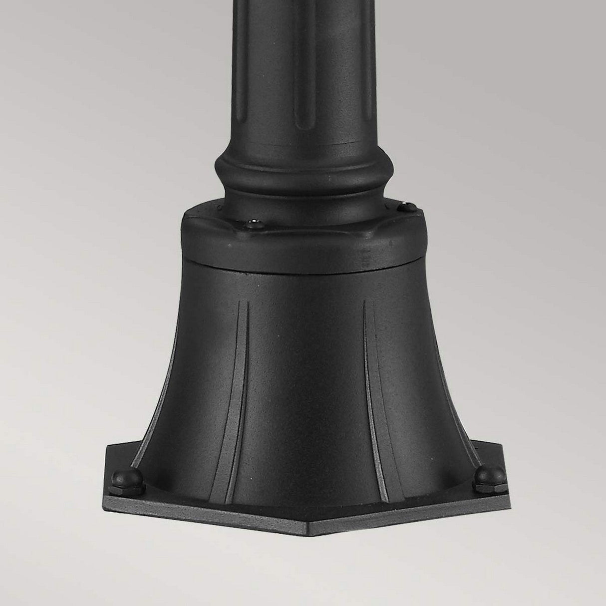 The Cotswold Lane 2 Light Outdoor Medium Pillar in black, featuring a design with vertical ridges and a flared bottom, rests on a light gray background. Its style evokes the charm of antique gas lanterns, adding an enchanting touch to any garden with its attractive outdoor lighting fixture appeal.