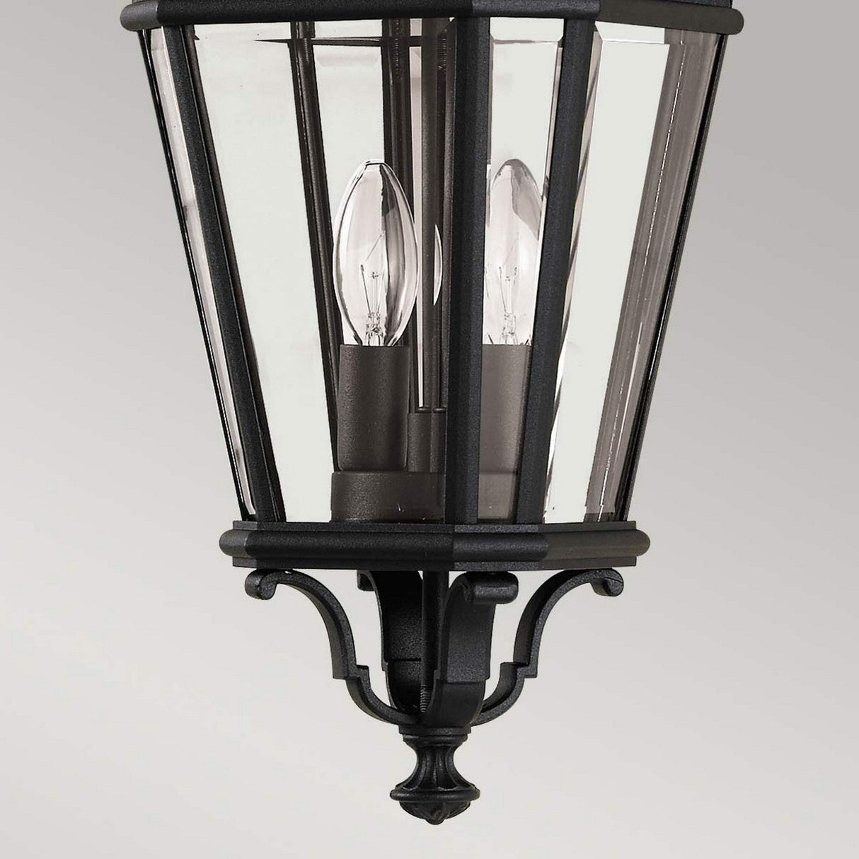 The Cotswold Lane 2 Light Outdoor Medium Chain Pendant in black features clear glass panels that highlight a charming two-light design with candle-like LED bulbs. The elegant decorative metalwork at the base imparts a classic and sophisticated touch, making it perfect for enhancing your exterior space.