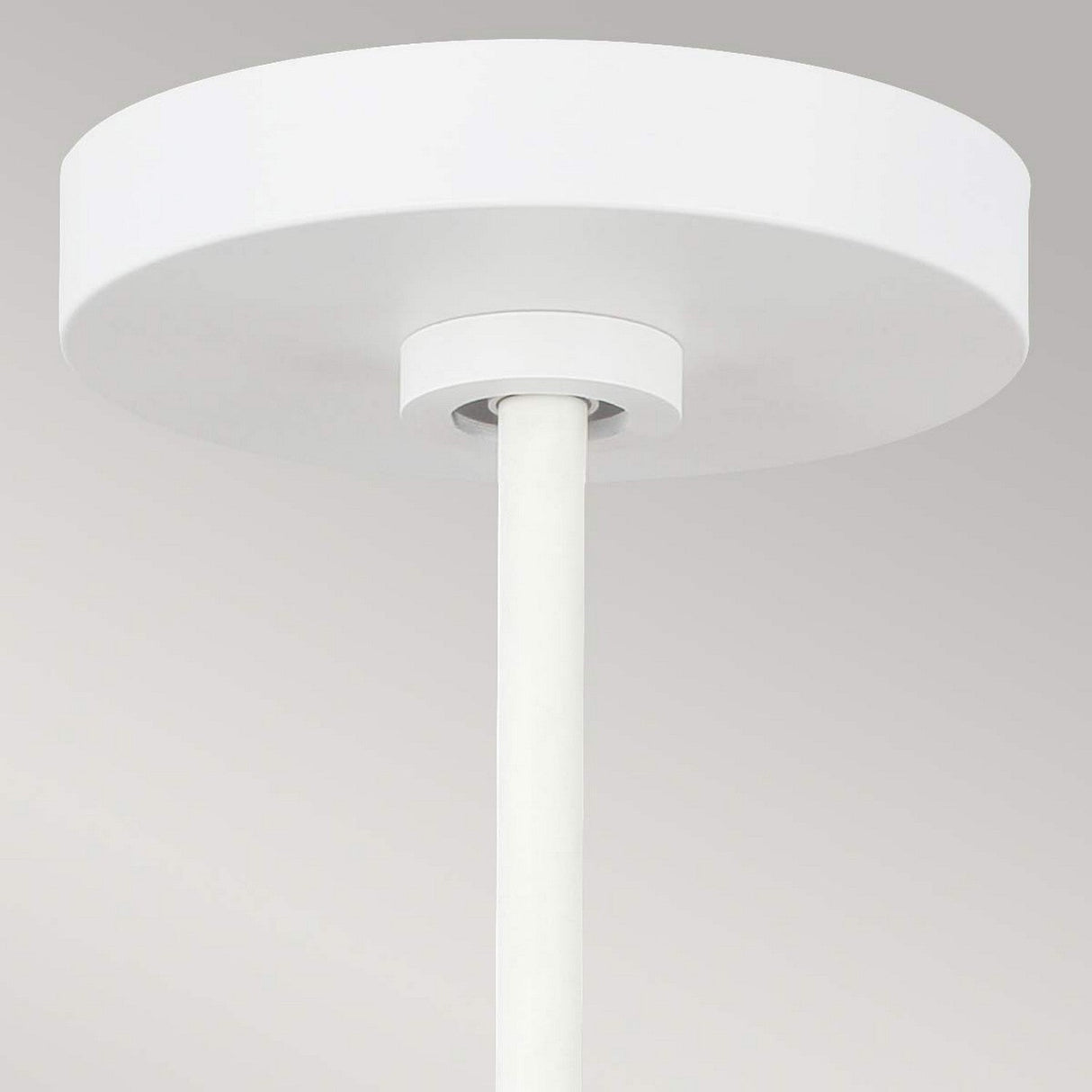 Close-up of an urban-style, minimalist matte white ceiling-mounted fixture featuring a cylindrical rod extending downward from a round base against a light gray background. This Darwin 1 Light Pendant is height adjustable to perfectly suit your space.