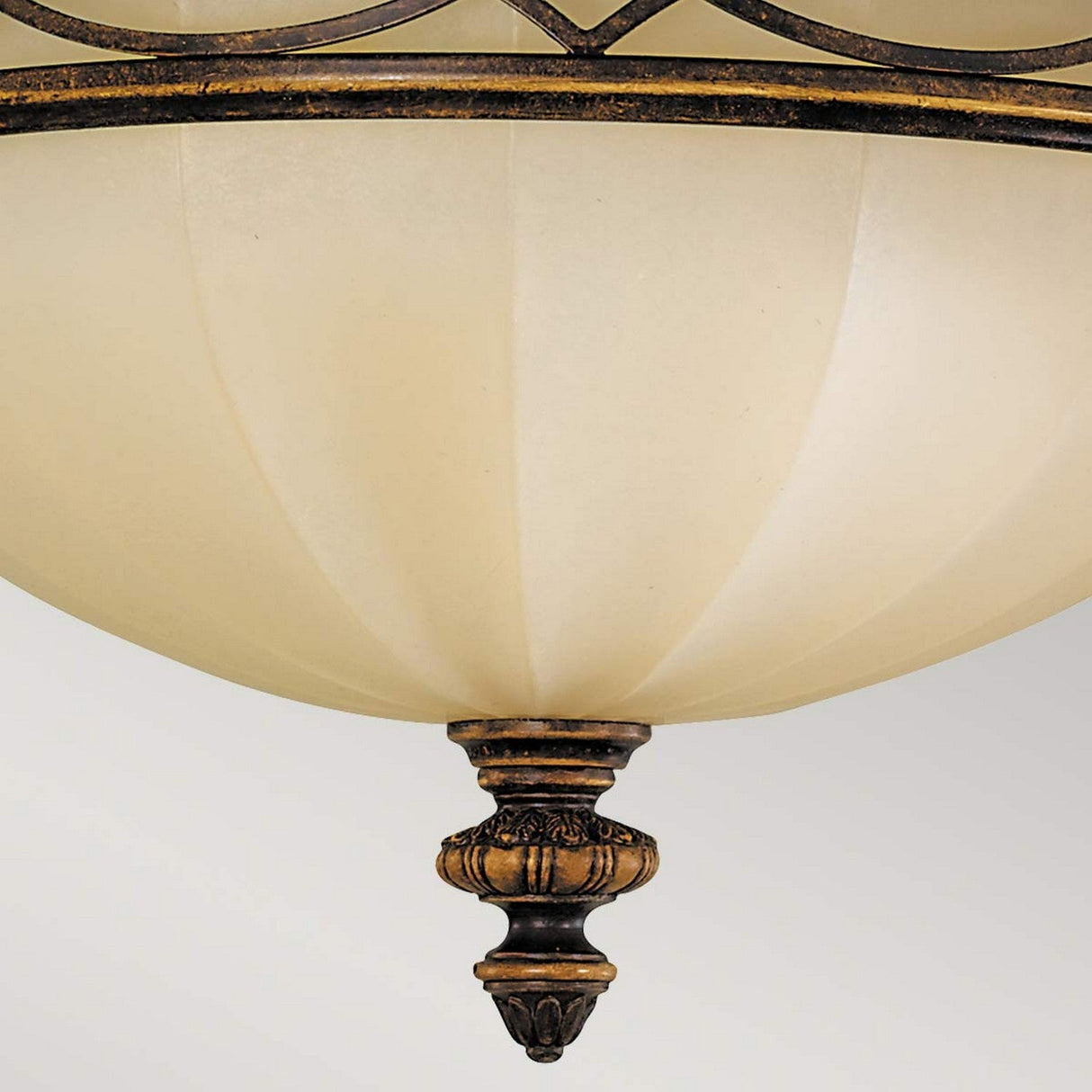 Close-up of the Drawing Room 3 Light Flush - Walnut, featuring a frosted glass globe and decorative bronze accents. The walnut finish and intricate Edwardian design details on the finial lend it a classic and elegant appearance against a soft, muted background.