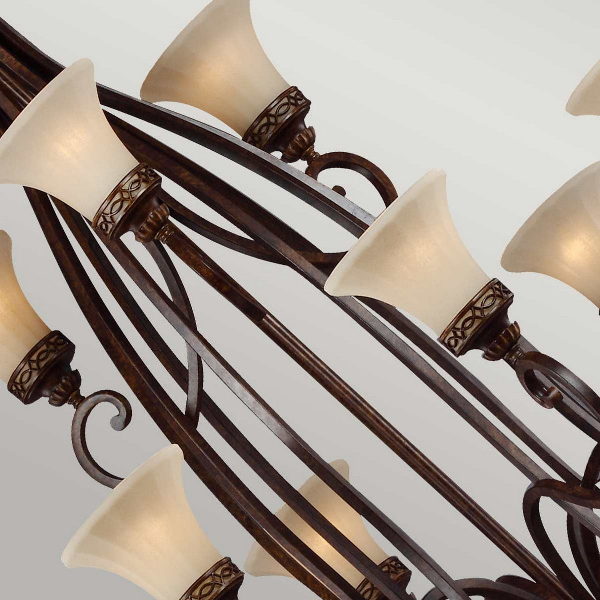 A detailed look at the Drawing 18 Light Chandelier - Walnut, featuring multiple frosted glass shades and a sophisticated walnut finish. With intricate scroll designs that echo Edwardian style, the elegantly curved arms add to its charm. The chandelier is shown with all lights off against a neutral backdrop.