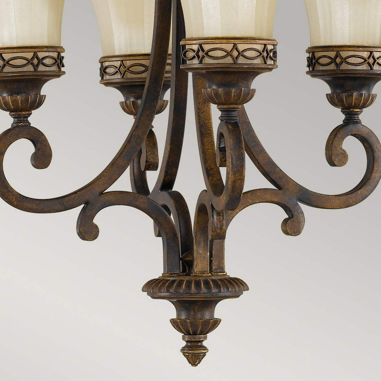 Close-up of the Drawing 4 Light Chandelier - Walnut, steeped in Edwardian tradition, featuring intricate scrolls and decorative patterns. The fixture holds several frosted glass shades, offering an elegant and classic look against a light gray background.