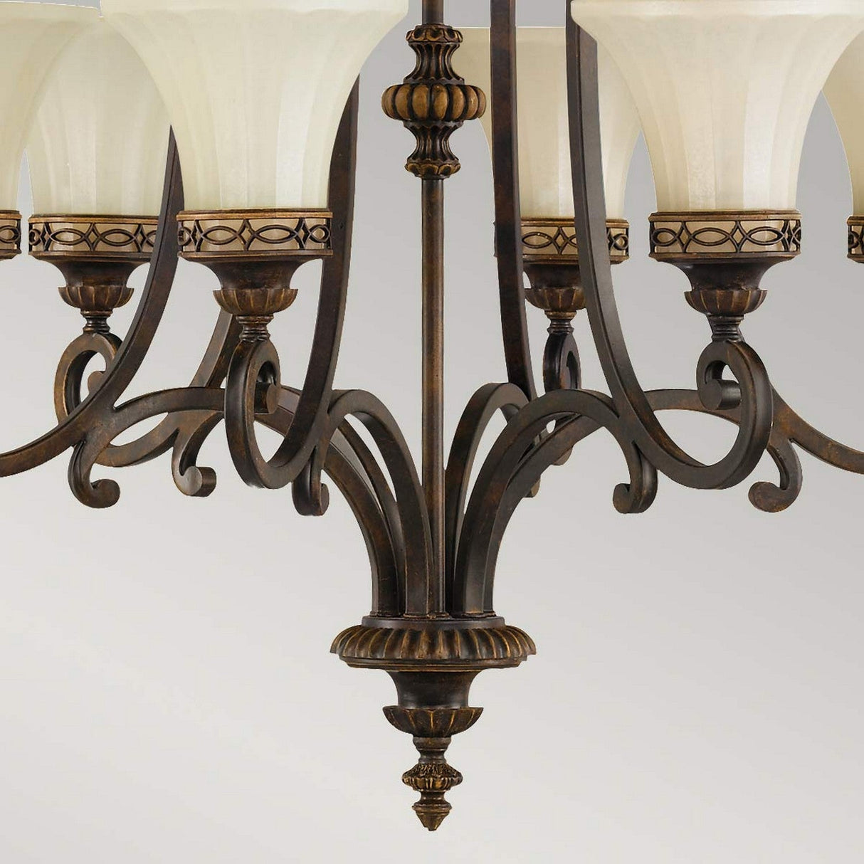 Close-up of the Drawing Room 6 Light Chandelier in walnut finish, featuring an ornate Edwardian style with multiple arms and frosted glass shades. The design showcases intricate scrollwork and decorative elements, offering a classic, elegant appearance against a neutral background.