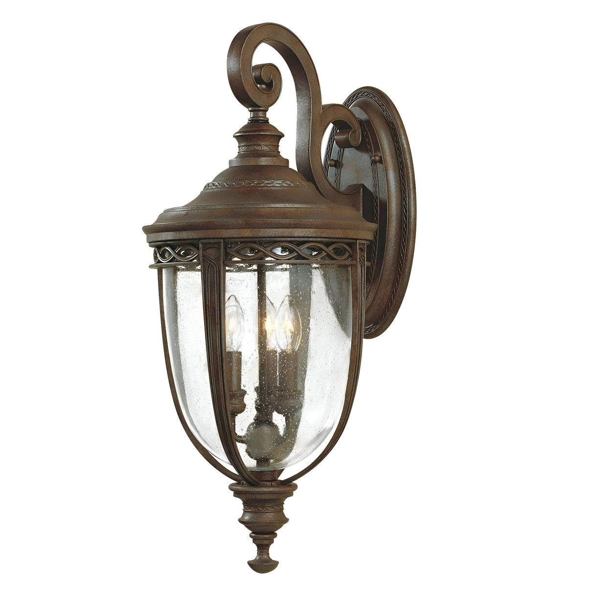 Introducing the English Bridle 3 Light Outdoor Large Wall Lantern in Bronze—an antique-style lighting fixture with seeded glass panels, perfect for outdoor settings. It features a curved arm and decorative finial, houses three light bulbs, and showcases ornate detailing for a timeless appeal.