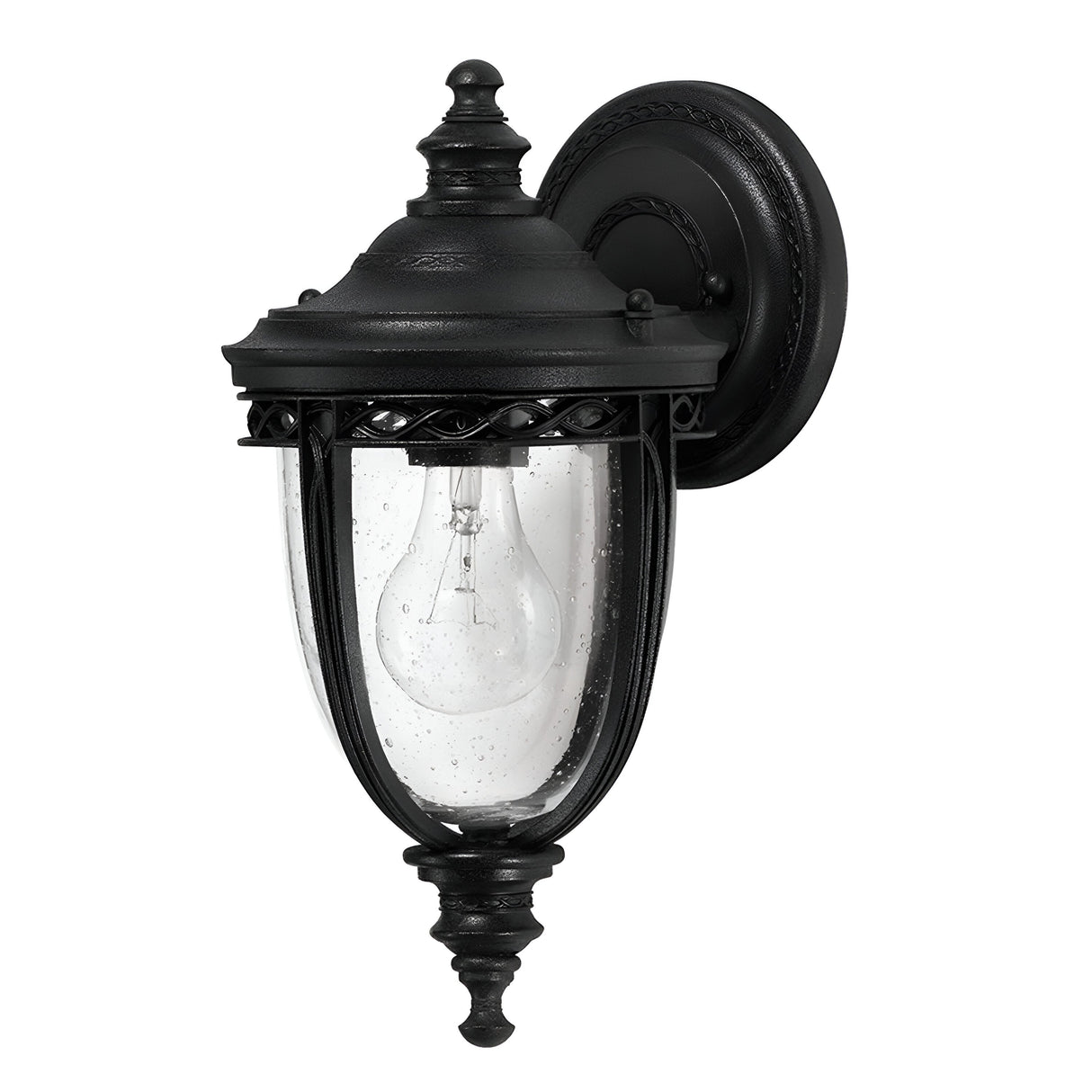 The English Bridle 1 Light Outdoor Small Wall Lantern in black features a timeless design with intricate detailing and clear glass housing that showcases the light bulb. Mounted on a circular black base, this elegant outdoor wall sconce adds sophistication to any exterior space.