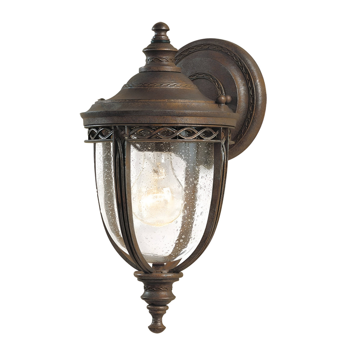The English Bridle 1 Light Outdoor Small Wall Lantern in British Bronze Finish boasts intricate detailing and features a clear glass cover that elegantly reveals the visible bulb inside, exuding a vintage style.