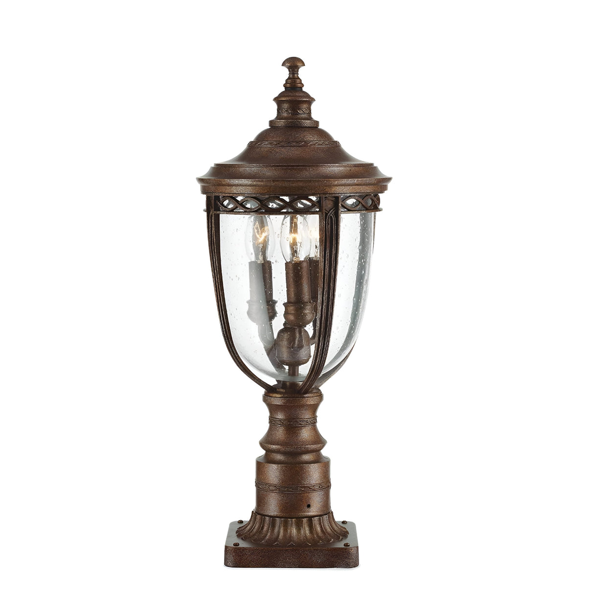 The English Bridle 3 Light Outdoor Medium Pedestal - Bronze features an antique-style bronze finish. This elegant lantern is designed with a glass cover that houses three candle-like bulbs, complete with seeded glass effects, and includes a decorative top. Its classic design is highlighted by the square base.