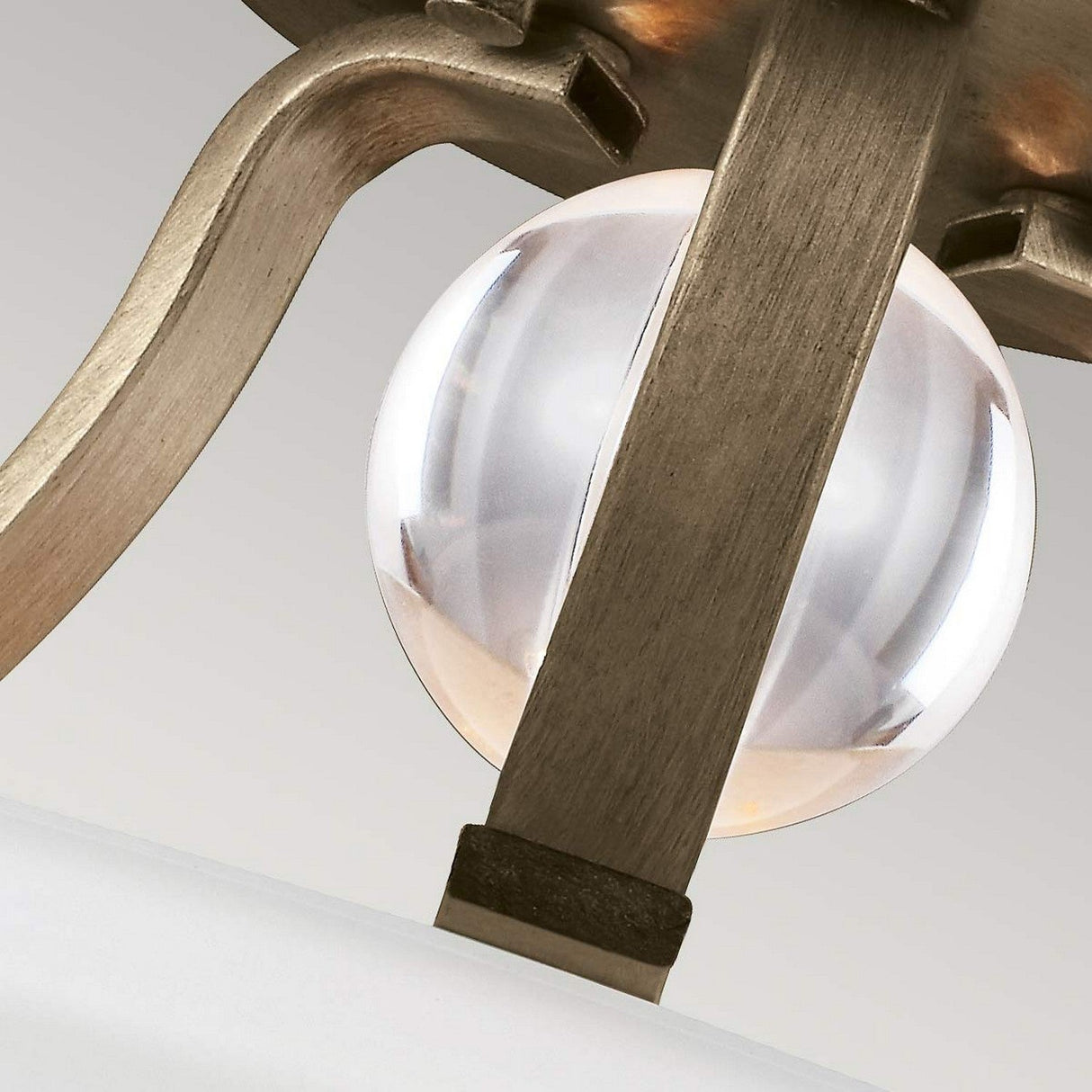 Close-up view of the Evington 2 Light Semi Flush in gold, featuring a modern metallic frame with curved arms and a clear, blown opal etched glass orb centerpiece, set against a neutral background.