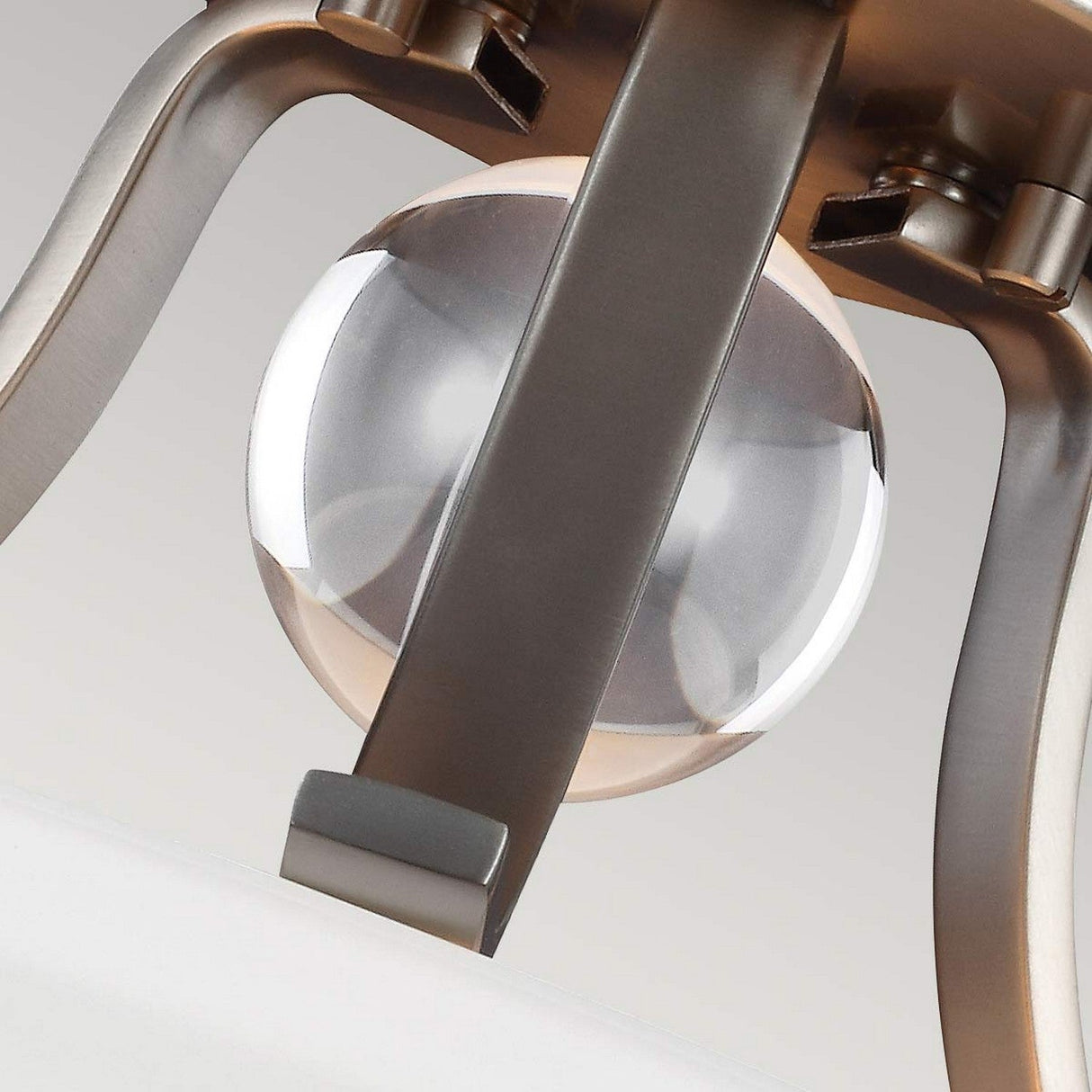 Close-up of the Evington 2 Light Semi Flush fixture showcasing its frosted glass sphere elegantly encased in a satin nickel support structure. The semi-flush design is minimalist and refined, with a gentle reflection on the sphere's surface.