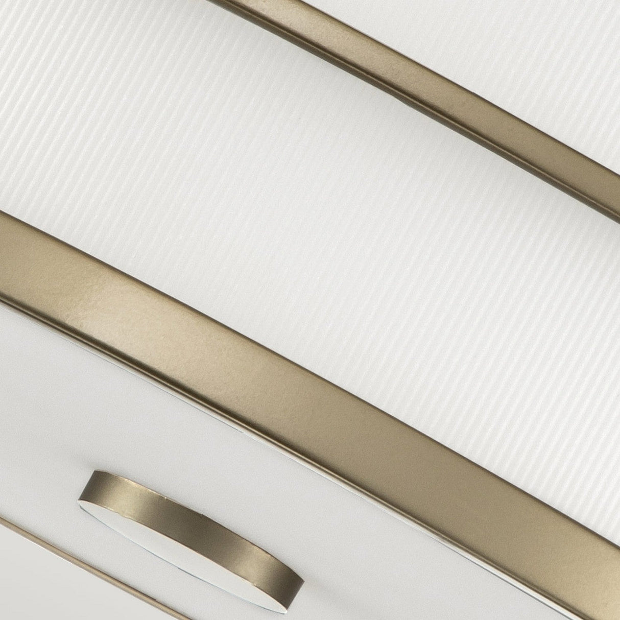 A close-up of the Fusion 3 Light Flush in painted natural brass showcases its modern ceiling design with ribbed glass shades and metallic accents. This piece features curved lines and circular elements, offering an elegant and contemporary aesthetic.