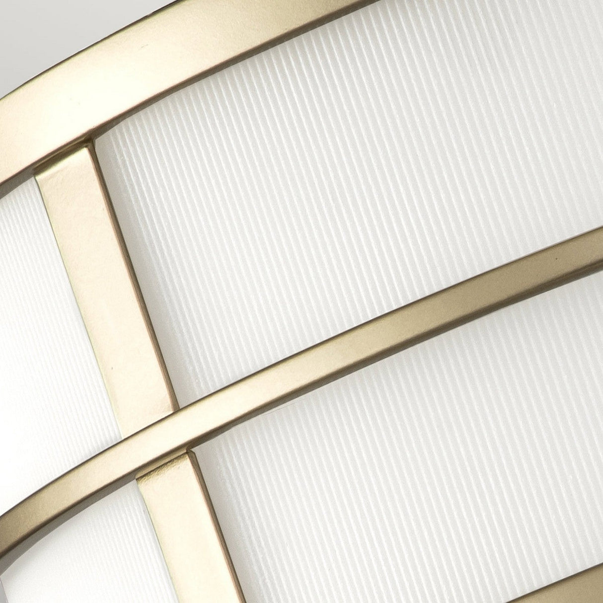 Close-up of the Fusion 3 Light Flush, showcasing ribbed glass shades and a metallic gold grid-like pattern in painted natural brass, creating a striking geometric design.