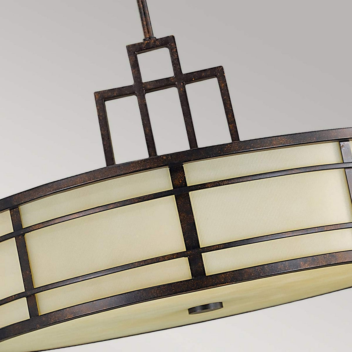 The Fusion 3 Light Chandelier in Grecian Bronze showcases a close-up of its modern circular design with a geometric metal framework. Reminiscent of the Arts & Crafts movement, this fixture features a frosted glass panel to diffuse light evenly throughout the space.