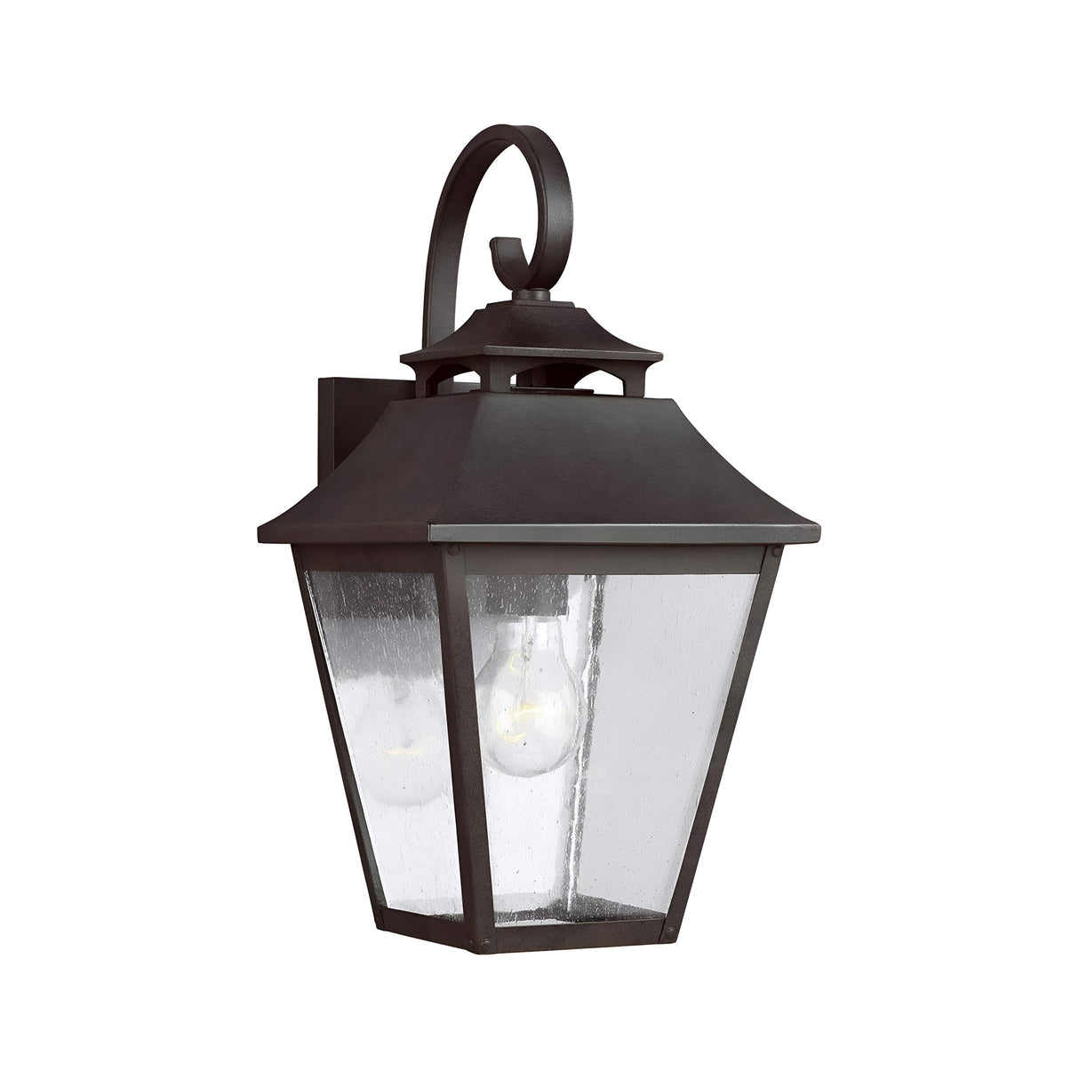The Galena 1 Light Outdoor Medium Wall Lantern - Sable is a black metal lantern featuring a classic design with a square base, sloped roof, and seeded glass panes. It accommodates a single light bulb and is adorned with an elegant decorative scroll accent on top. With its IP44 rating, this lantern provides both charm and durability to enhance your exterior spaces.