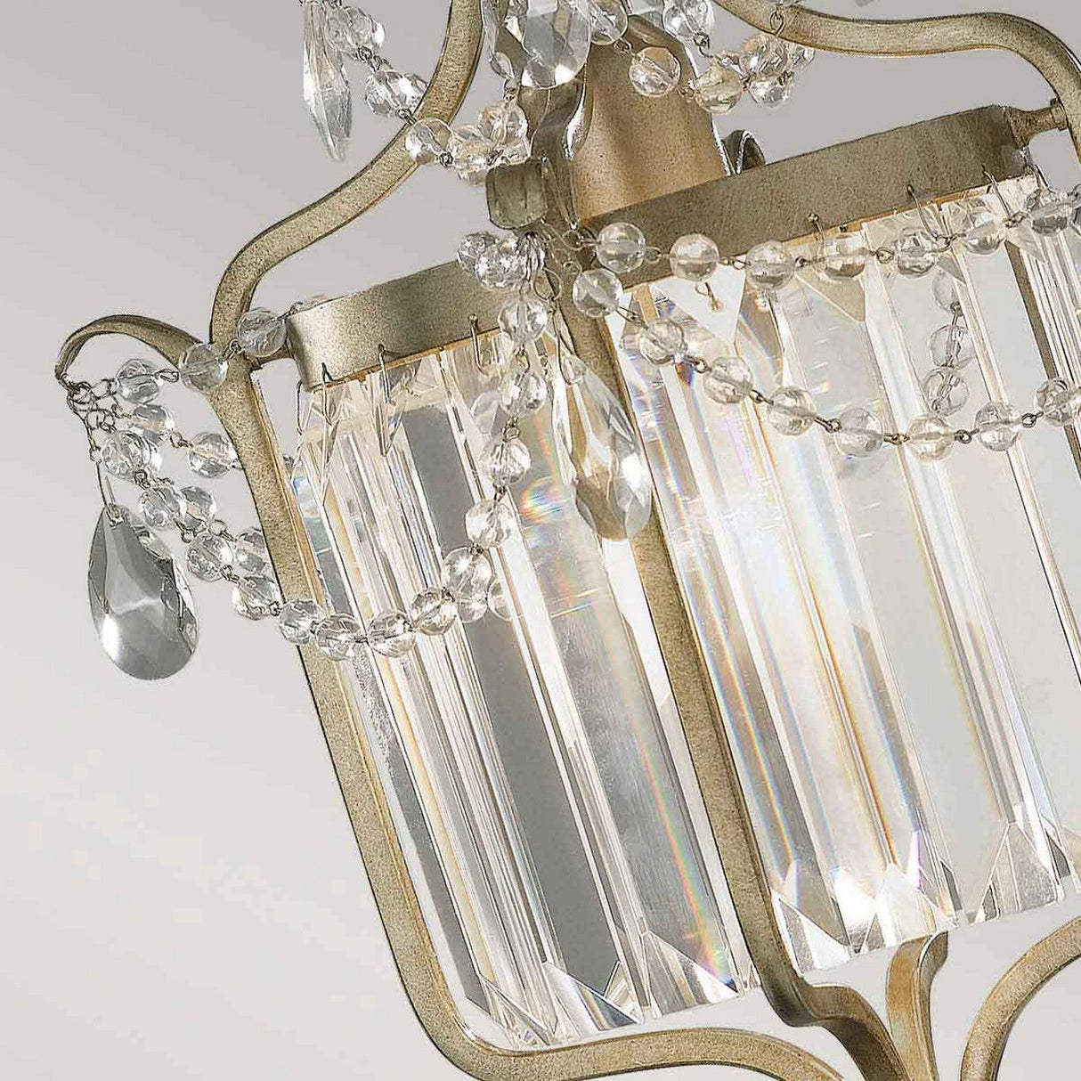A close-up of the Gianna 1 Light Pendant in Gilded Silver showcases its elegant design with crystal adornments and glass pendants that beautifully reflect light. The metallic accents of this piece exude timeless elegance, adding a touch of luxury and sophistication that is reminiscent of Italian interiors.