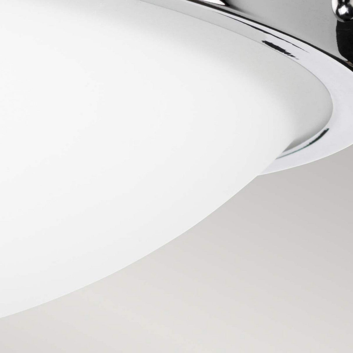 Close-up of the contemporary Gravity 2 Light Flush - Polished Chrome ceiling fixture, showcasing a smooth white glass dome shield and polished chrome rim, set against a plain, light gray ceiling.