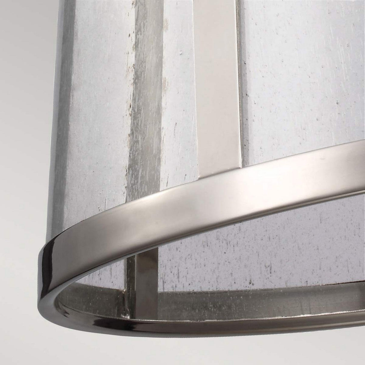 Close-up of a contemporary lampshade featuring a metallic frame and translucent fabric, similar to the Harrow 1 Light Medium Pendant in Polished Nickel. The sophisticated texture complements its polished nickel components, while neutral color tones accentuate its minimalist design and sleek look.