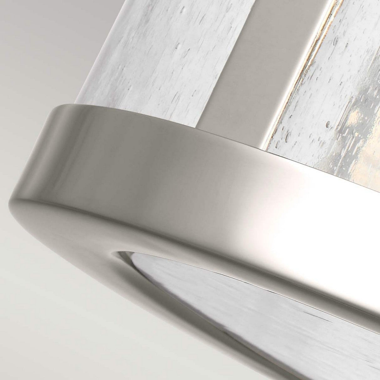 A close-up of the Harrow 2 Light Semi Flush in Polished Nickel showcases its modern design with a cylindrical clear seeded glass shade. The textured glass surface adds contemporary style set against a neutral background.