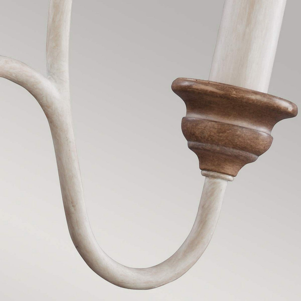 Close-up of the Hartsville 3 Light Chandelier in Chalk Washed/Beachwood, featuring a smooth finish ideal for coastal casual spaces. The design incorporates light wood with a darker, rounded end piece, evoking rustic elements. It is set against a neutral gray background.