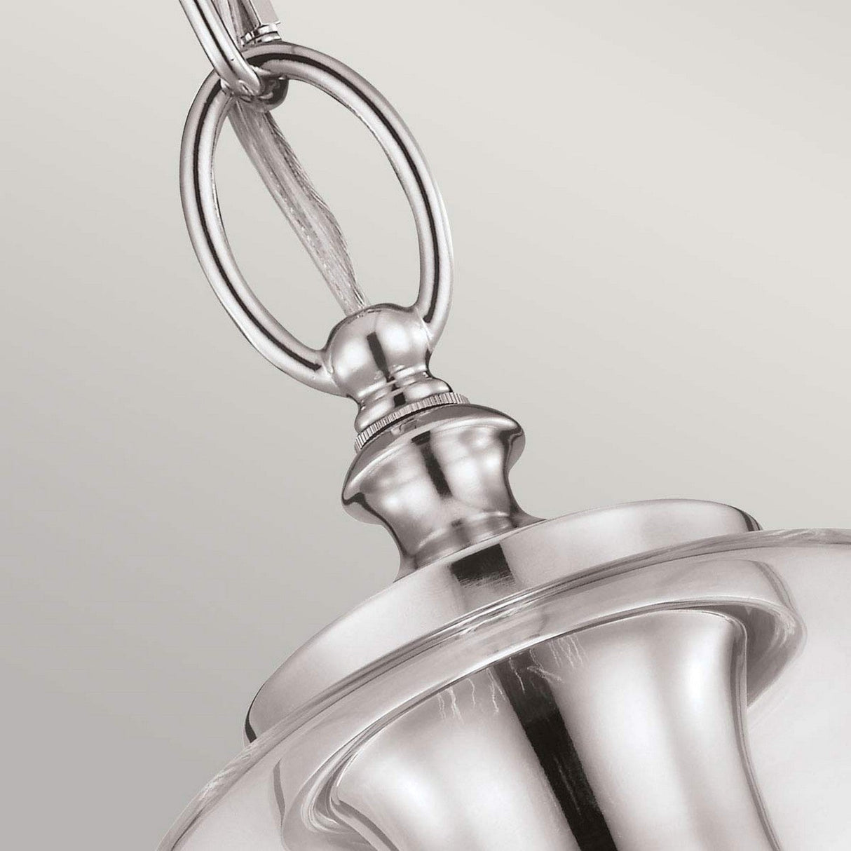 Close-up of the Hounslow 1 Light Pendant, beautifully crafted with a polished nickel finish and a clear glass shade. Elegantly designed, it includes a loop detail for hanging, all set against a neutral background.