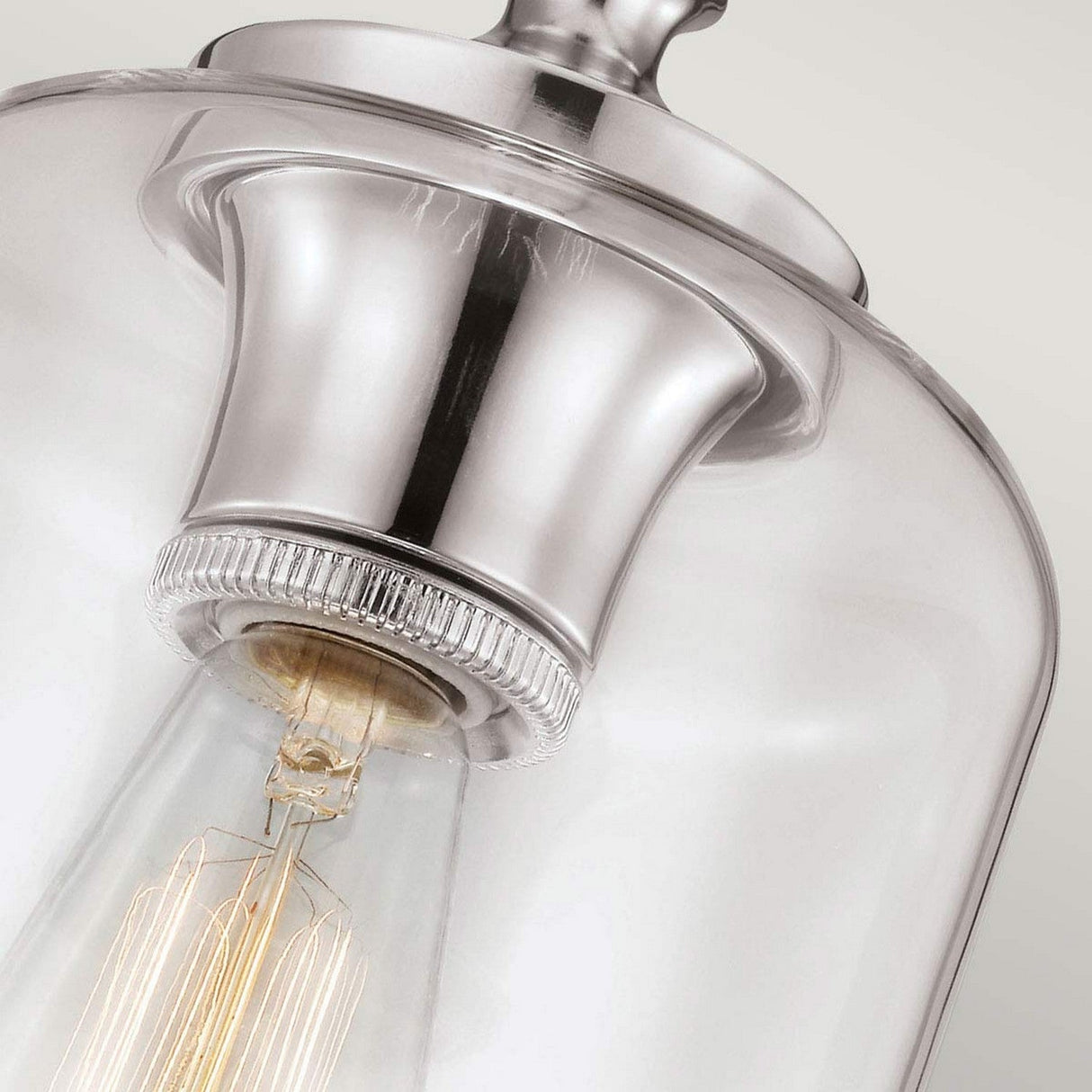 Detailed shot of the Hounslow 1 Light Pendant, showcasing its clear glass shade and visible filament bulb. The fixture features a sleek polished nickel finish, highlighting its minimalist design against a neutral backdrop.