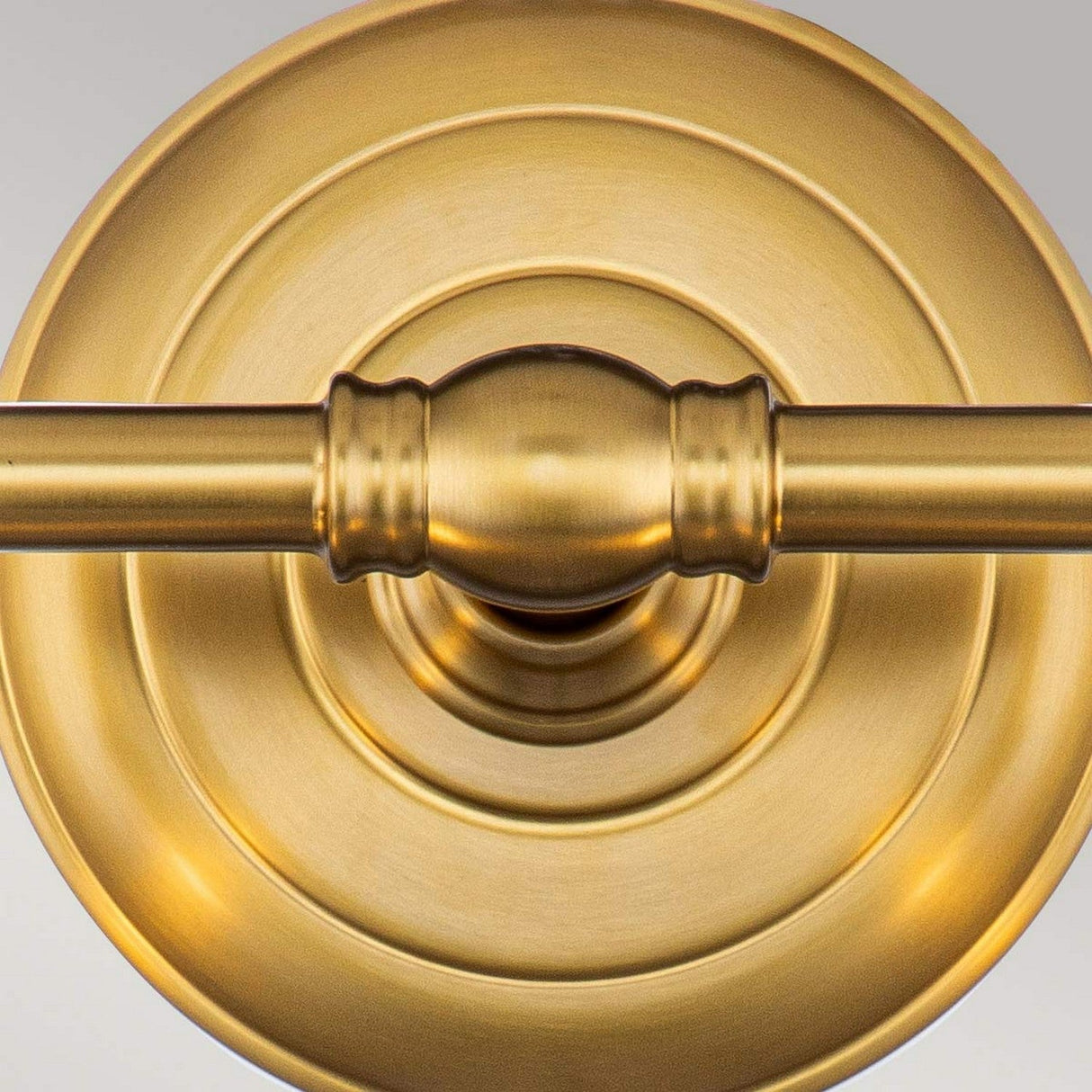 Close-up of a burnished brass door handle with a circular backplate showcasing a smooth, polished finish. The horizontally aligned handle captures the symmetry and metallic sheen reminiscent of the fine craftsmanship found in the Huguenot Lake 2 Light Wall Light - Burnished Brass.
