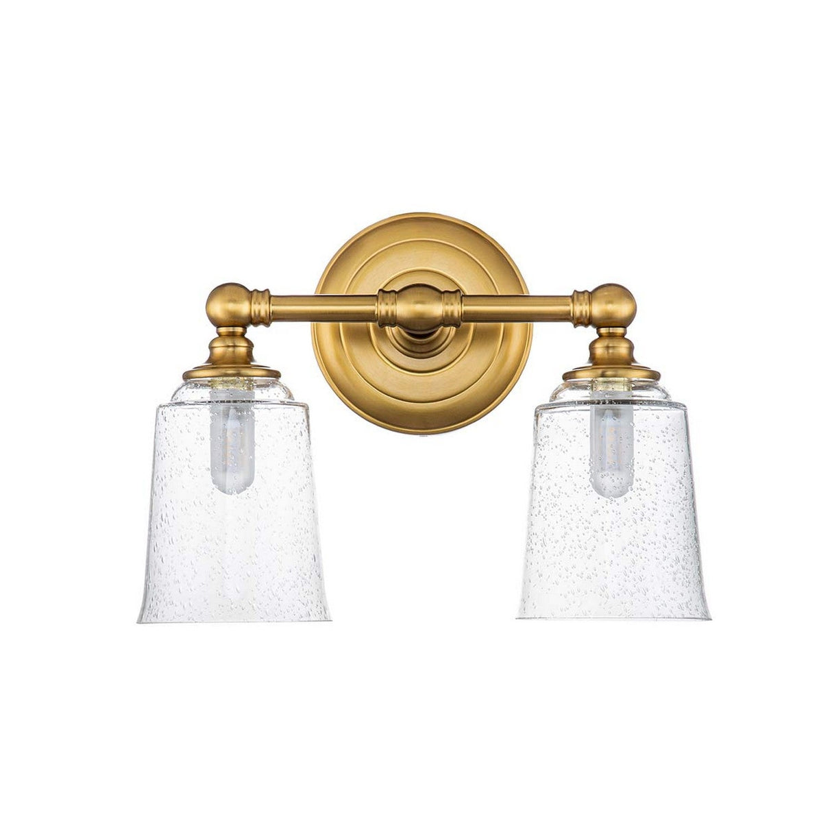 The Huguenot Lake 2 Light Wall Light in Burnished Brass showcases a refined design with two seeded glass lampshades, each boasting a subtle textured pattern. This wall-mounted fixture features a round base and an elegantly designed connecting rod that holds the shades horizontally.