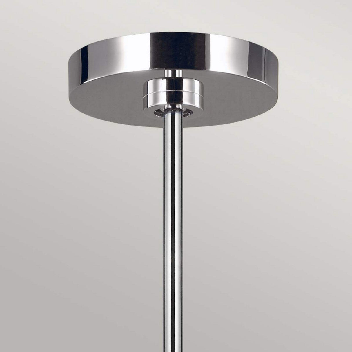 Close-up view of the Jax 10 Light Chandelier in polished nickel, showcasing a modern metallic design with a sleek, cylindrical rod descending from a round, reflective base. The background is a plain, light gray color.